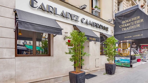 A building with a sign for 'CARLADEZ CAMBRONE' and 'BOUCHER CHARCUTIER TRAITEUR'. - Hotel Carladez Cambronne (Paris)