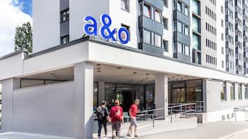 En moderne bygning med et tydeligt 'a&o'-skilt, store vinduer og et overdækket indgangsparti.