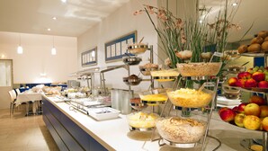 Un buffet proposant une variété de plats et agrémenté d’une composition florale décorative.