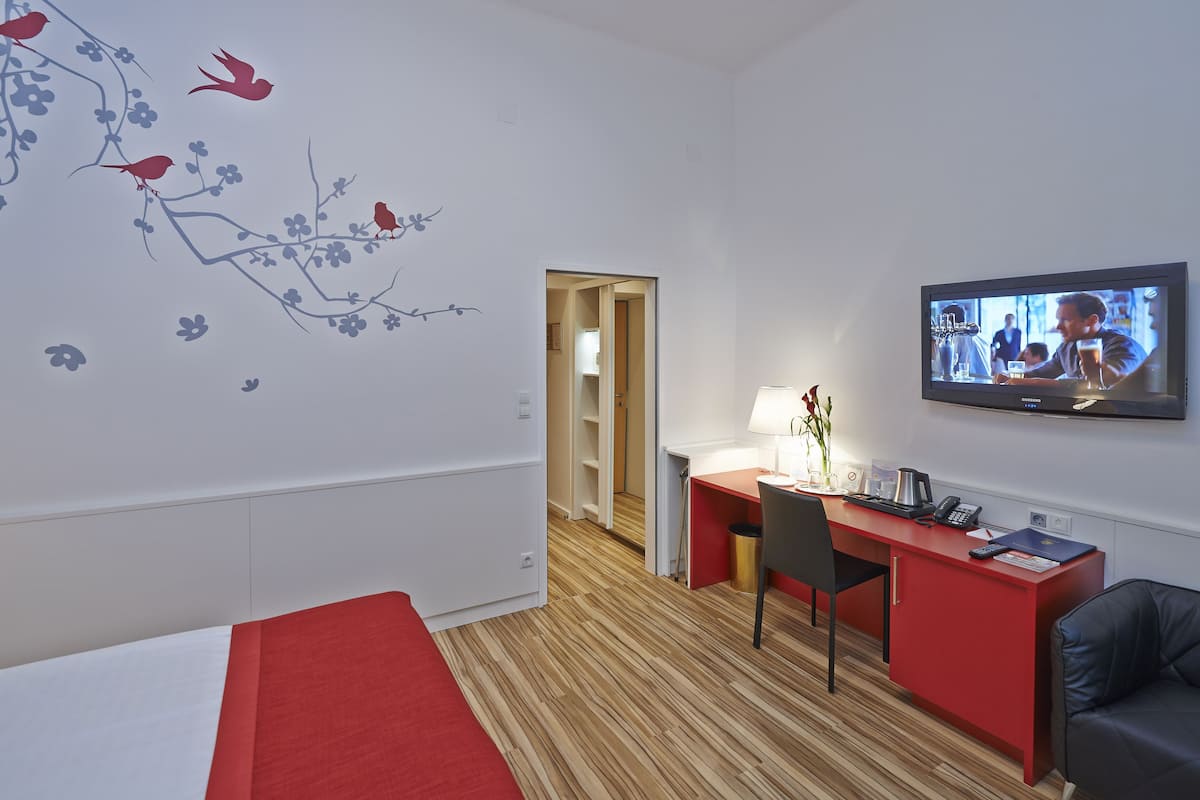 Habitación doble superior, balcón, vistas al jardín | Zona de estar | Televisión LCD de 37 pulgadas con canales por satélite, una televisión