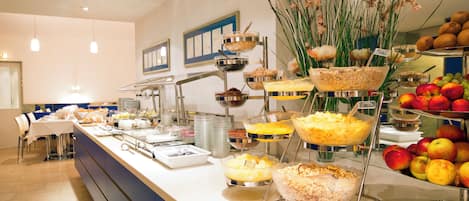 A buffet with various food items and a fruit display.