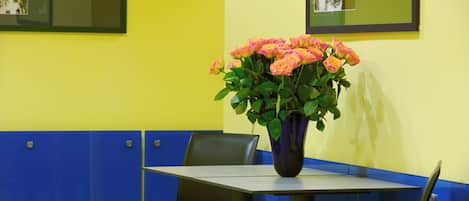 A table with a vase of flowers in a restaurant setting.