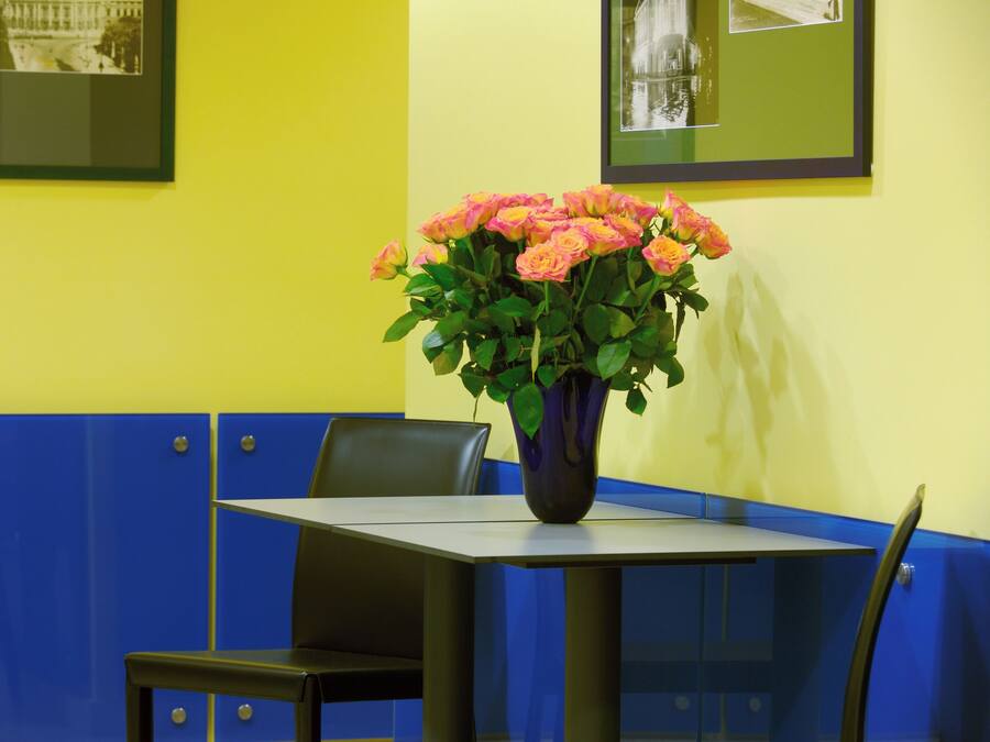 A table with a vase of flowers in a restaurant setting.