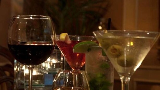 Three different types of glasses on a table, likely in a bar setting.