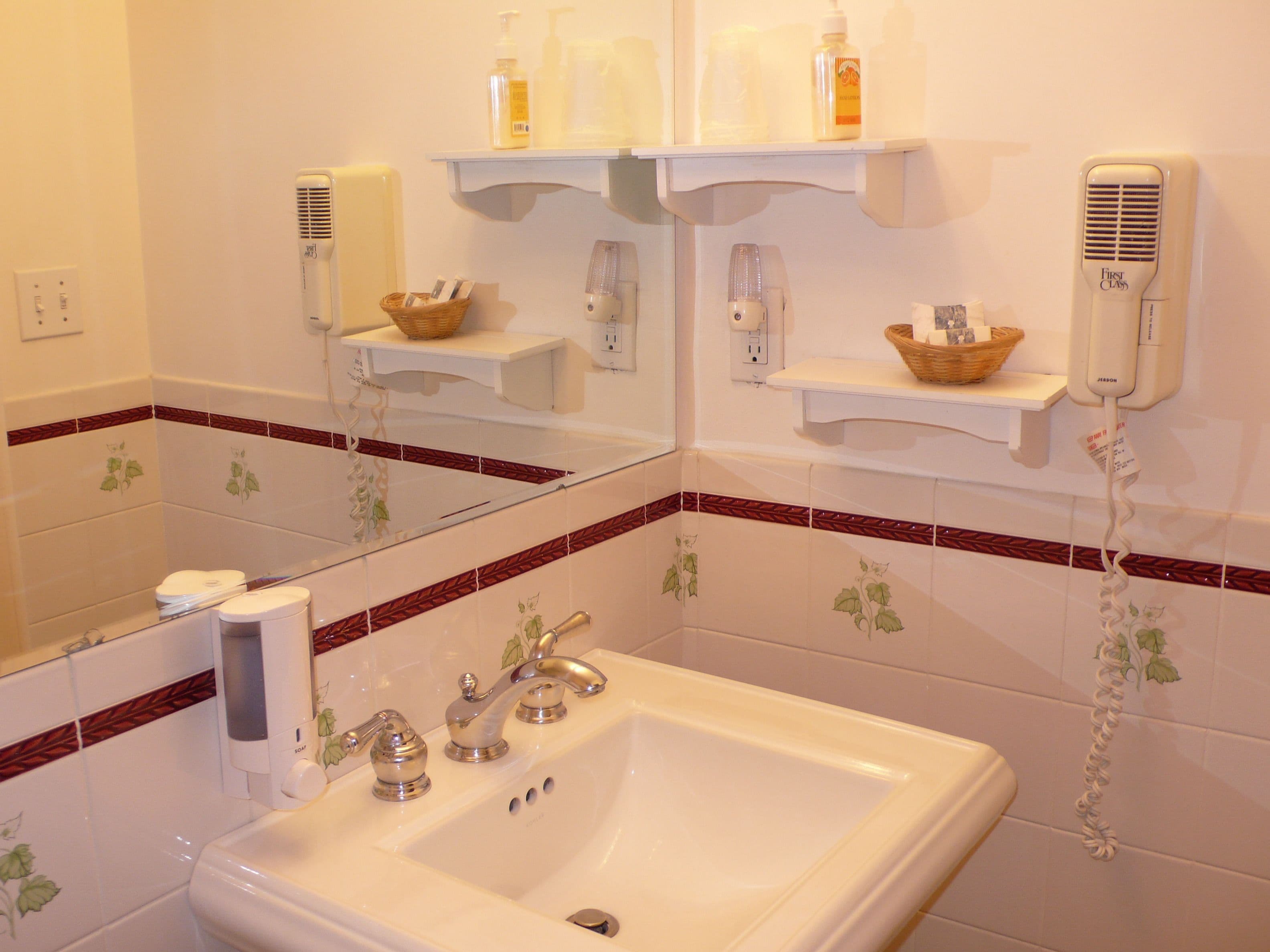 A bathroom with a sink, mirror, and shelves with toiletries.