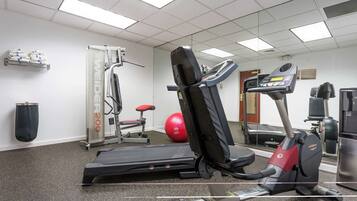 Una palestra con tapis roulant, ellittica e cyclette.