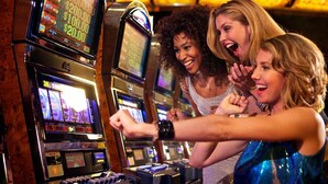 Un grupo de personas jugando a máquinas tragamonedas en un casino.