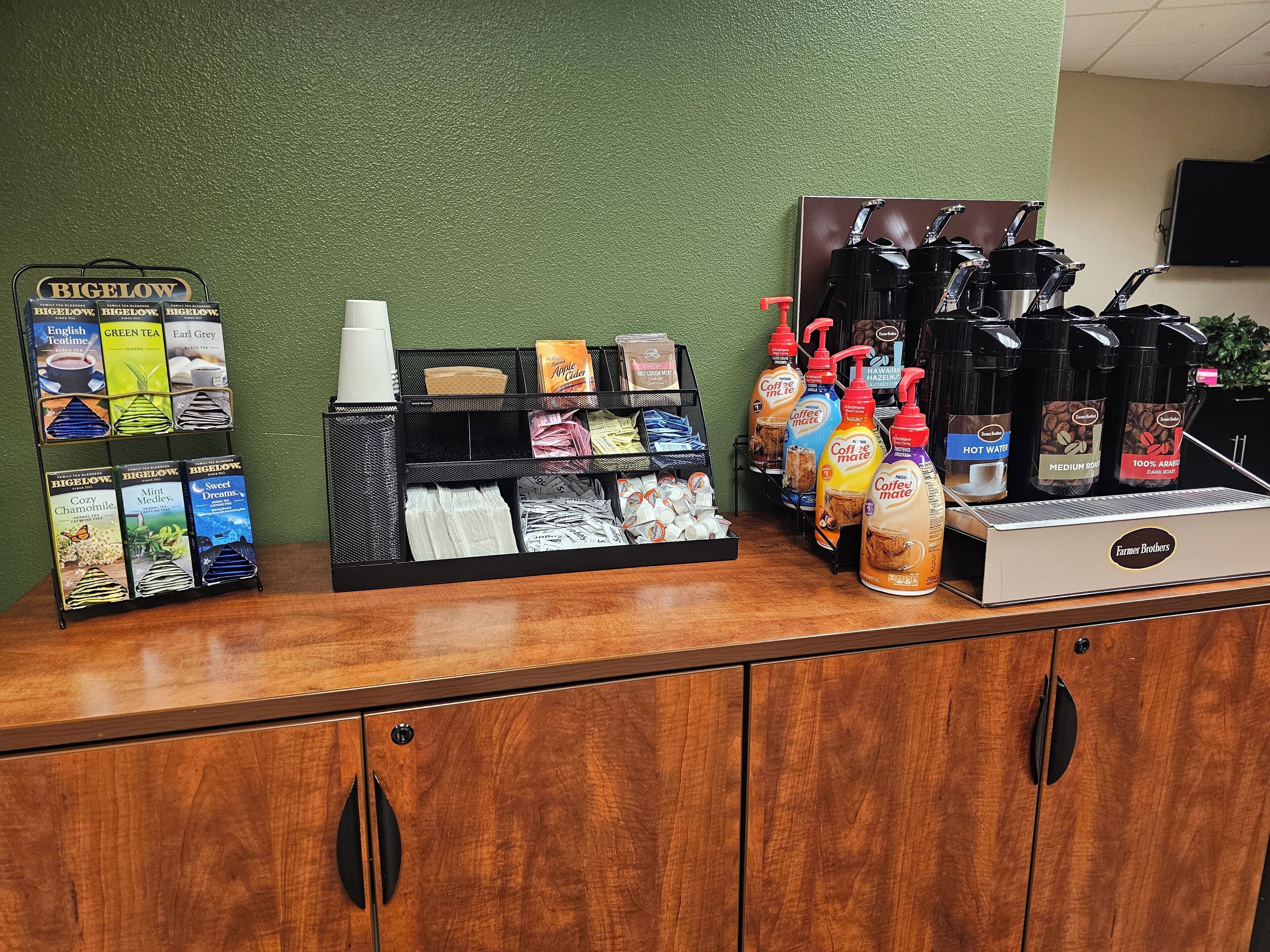 Un espace dédié aux boissons chaudes, où sont présentés divers produits à base de thé et de café, notamment des sachets et des bouteilles, sur un comptoir.