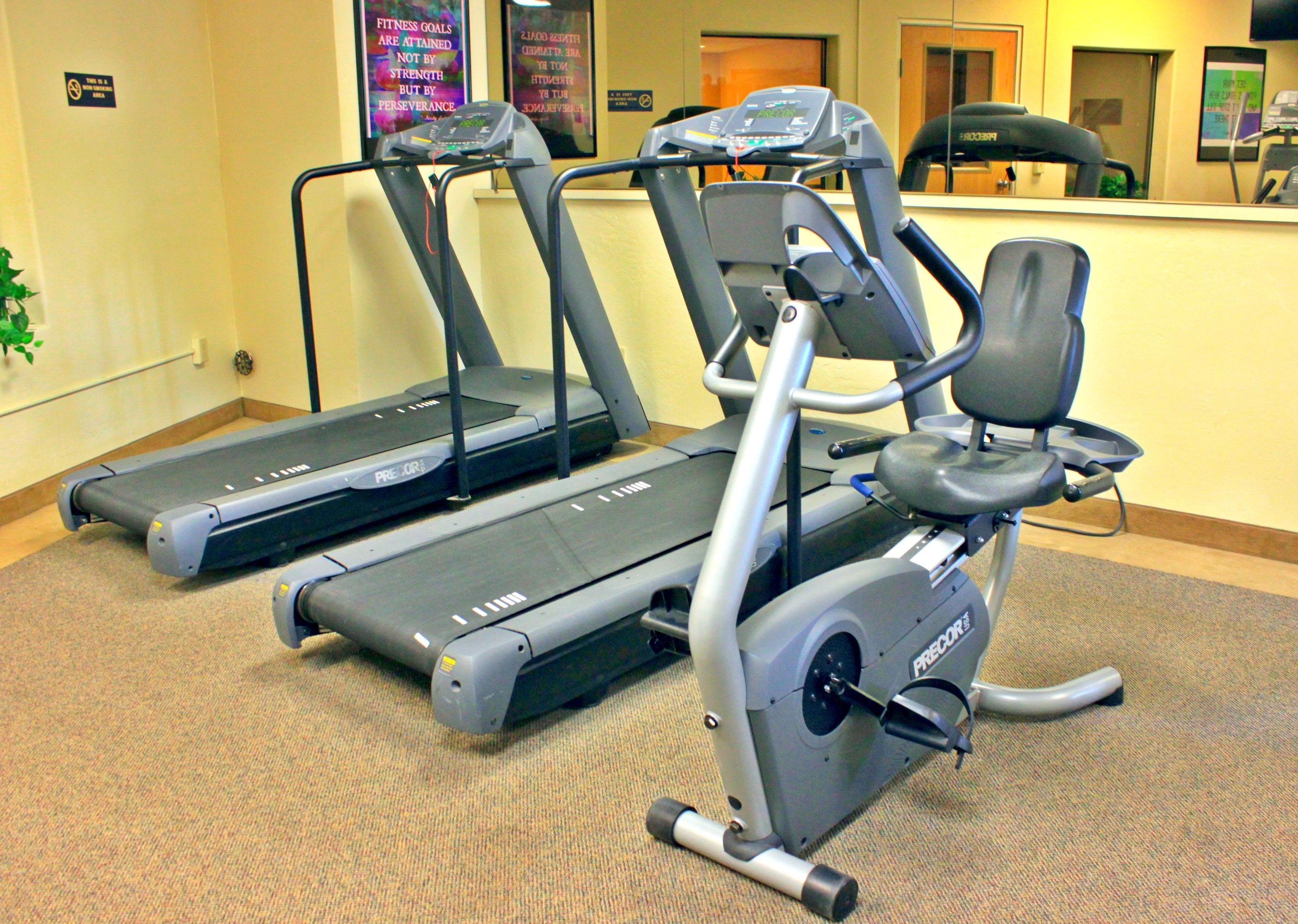 Un área de fitness con cintas de correr y una máquina elíptica.