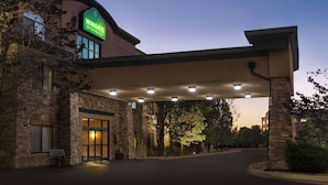 A hotel entrance with a stone facade, a covered walkway, and a sign that reads "Wingate by Wyndham." - Wingate by Wyndham Greenwood Village/Denver Tech (Greenwood Village)