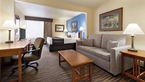 A hotel room with a bed, a sofa, a desk, and a chair. - Wingate by Wyndham Greenwood Village/Denver Tech (Greenwood Village)