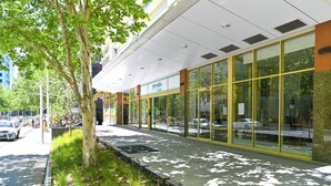 Een modern gebouw met grote glasramen en een overdekte doorgang.
