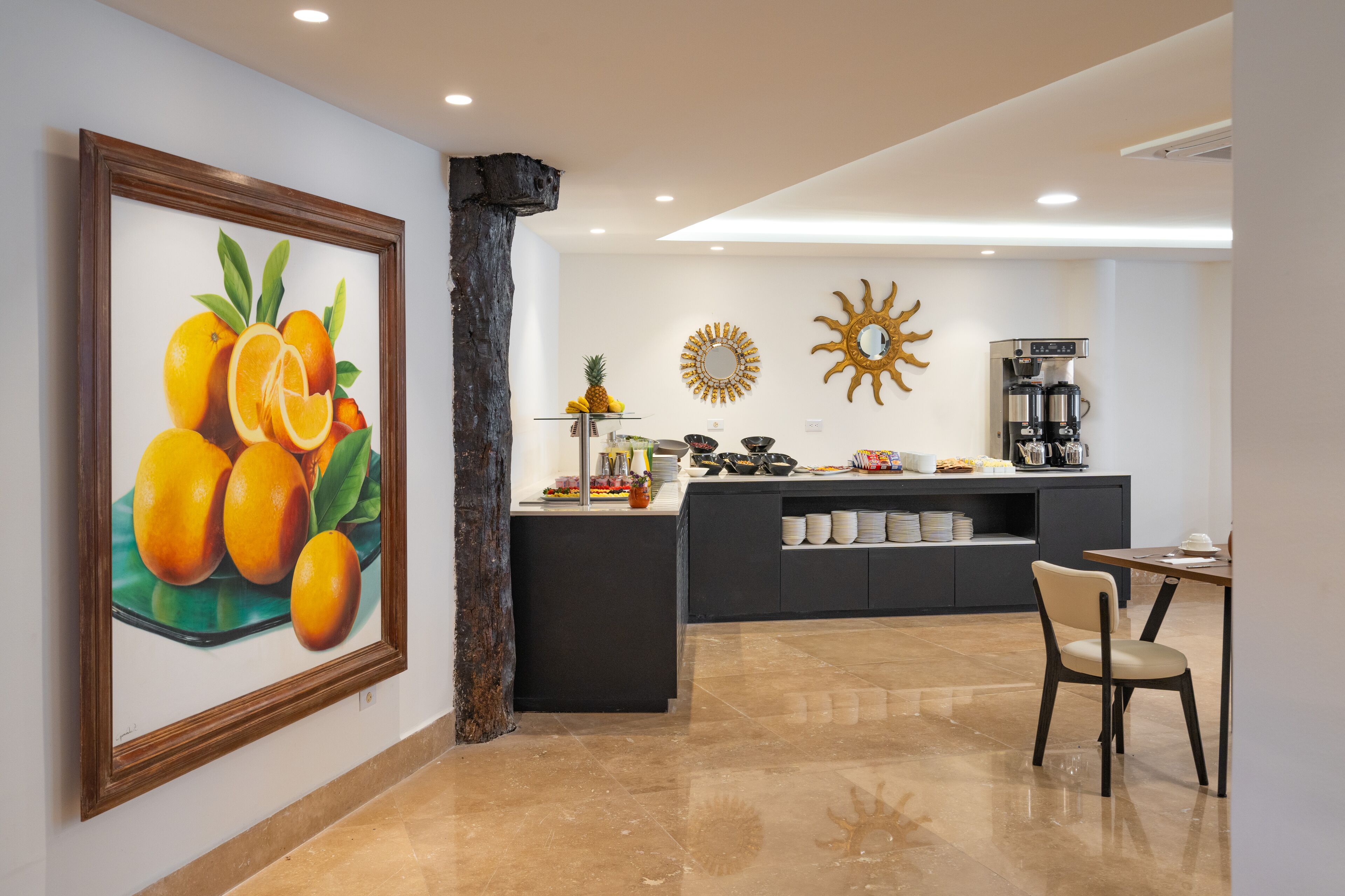 Una cocina moderna con una isla central, una cafetera y una exposición de frutas.