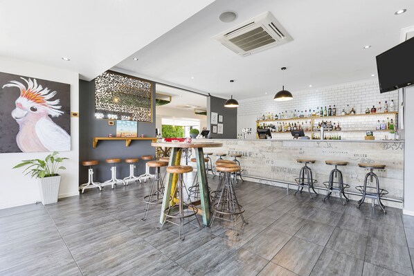 Enjoy a drink at the bar, where guests can sit on stools with comfortable seating.