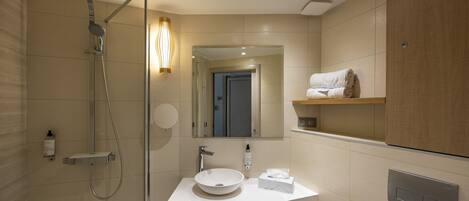 A modern bathroom with a shower, sink, and mirror.