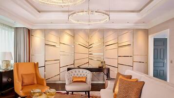 A modern living room with a sofa, armchairs, a coffee table, and a decorative wall panel.