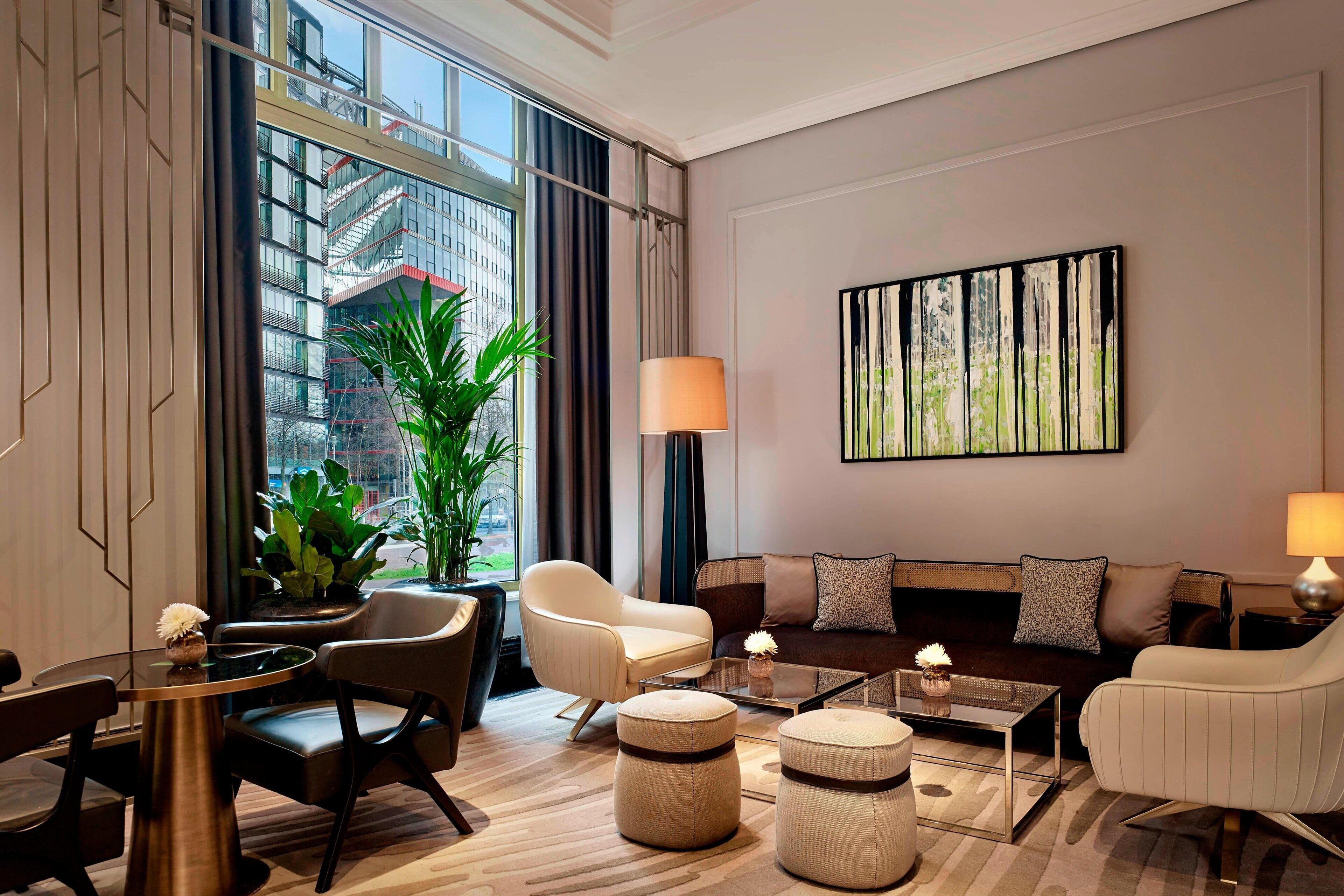 A modern living room with a sofa, armchairs, a coffee table, and a dining area.
