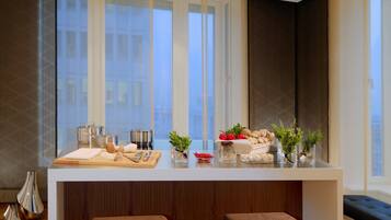 A modern kitchen with a central island, bar stools, and large windows.