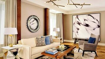 A modern living room with a sofa, armchairs, a coffee table, and a large abstract painting.