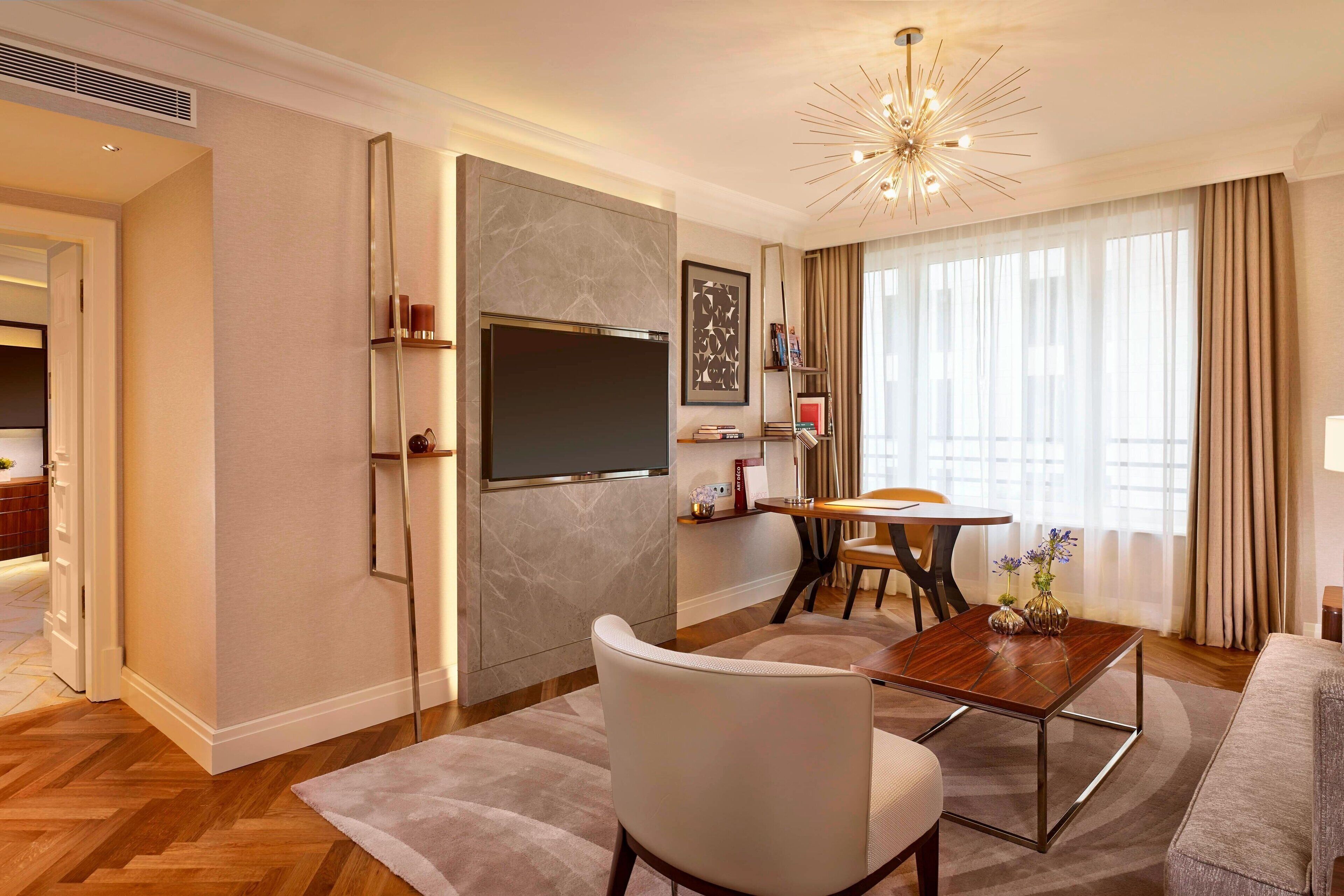 A modern living room with a flat-screen TV, a dining table, and a comfortable seating area.
