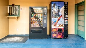 A vending machine with a tropical drink and a snack vending machine next to a door. - Americas Best Value Inn & Suites Flagstaff (Flagstaff)