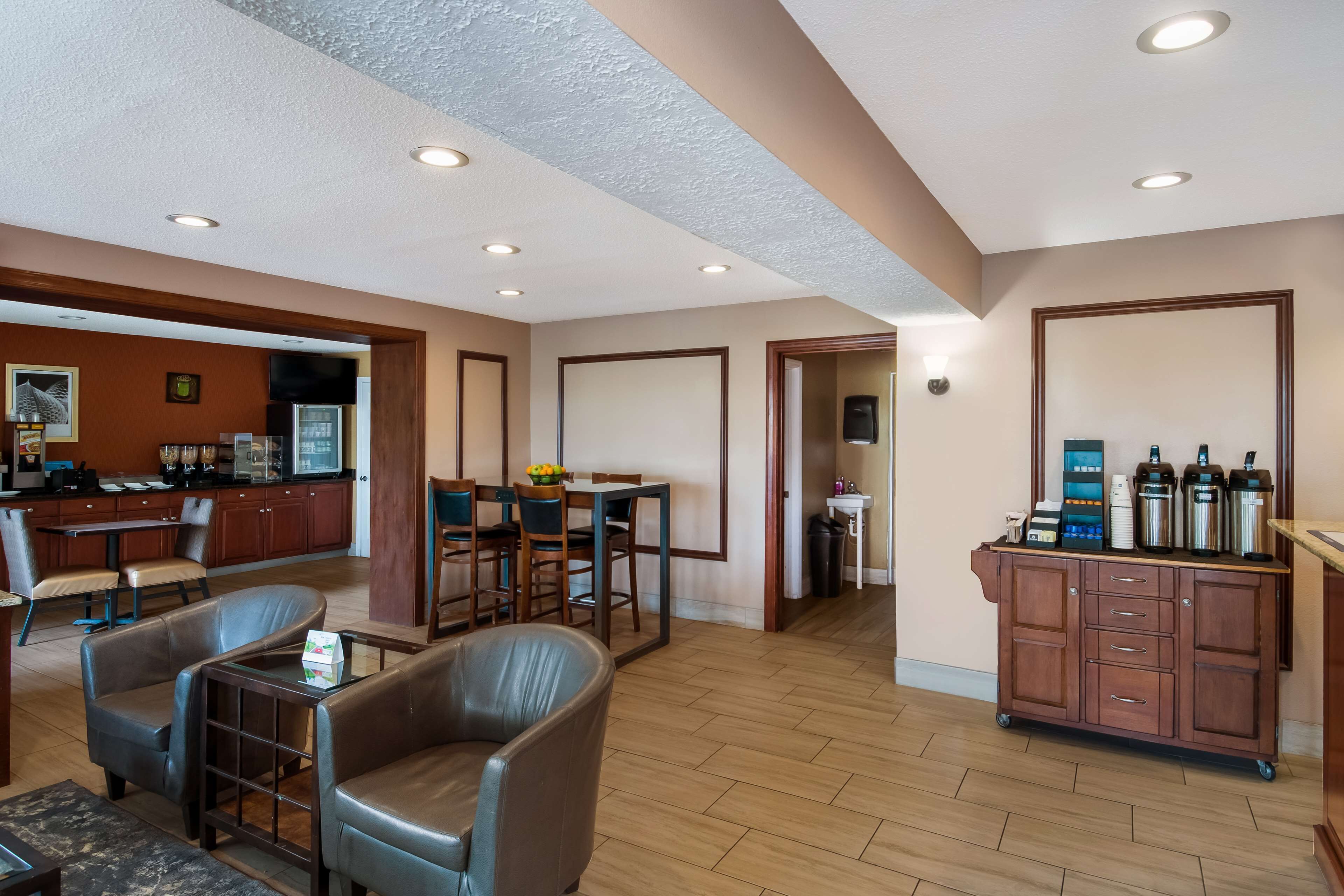 Een hotel lobby met lederen zitplaatsen, een kitchenette en een koffiehoek.