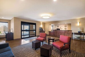 A hotel lobby with seating, a reception desk, and a view of the outside. - Comfort Inn Fort Morgan (Fort Morgan)
