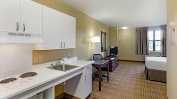 Escritorio, cortinas blackout y tabla de planchar con plancha