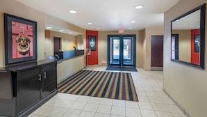 A hotel reception area with a reception desk, a framed artwork, and a striped carpet. - Extended Stay America Select Suites - Columbia - Stadium Blvd. (Columbia)