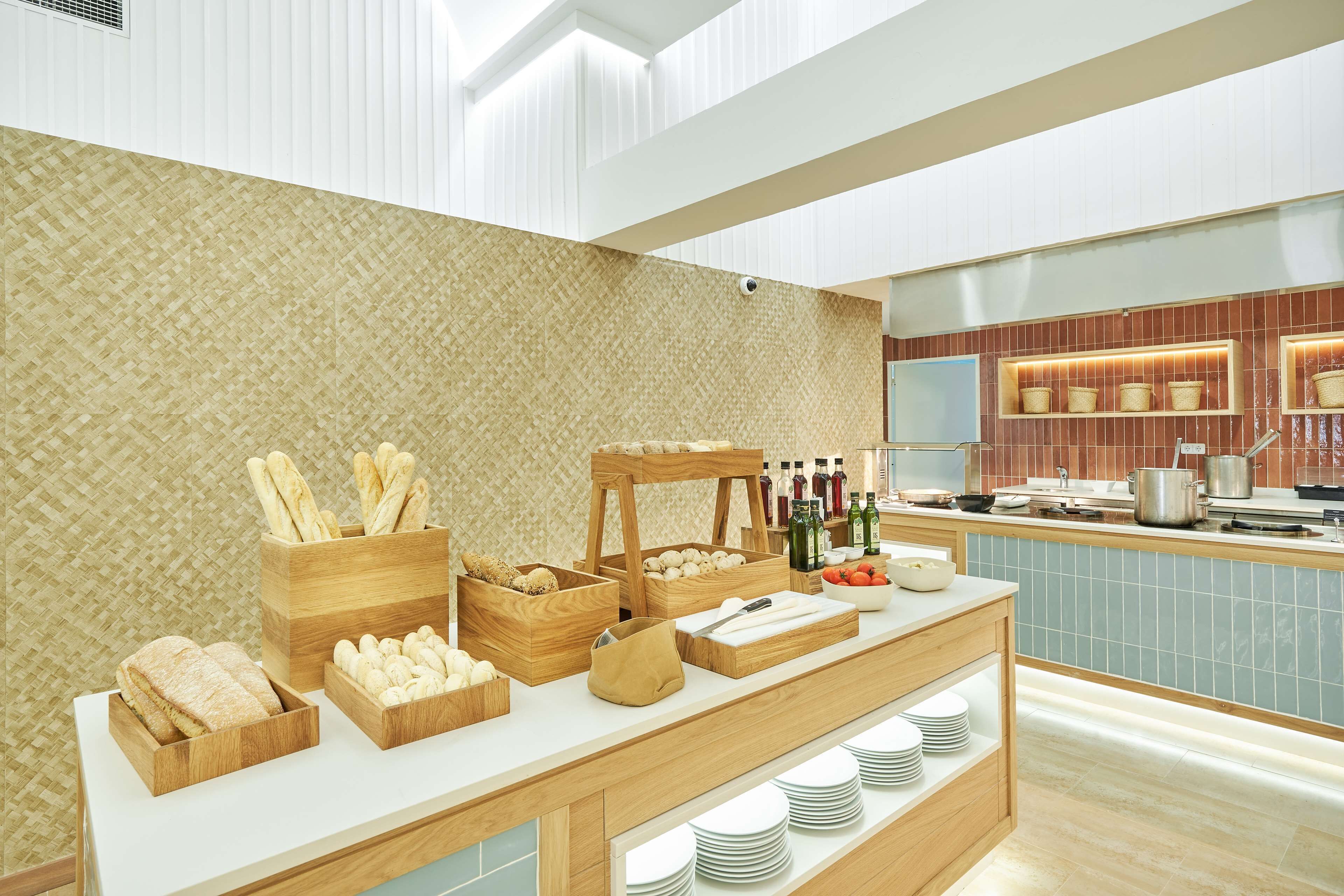 Montaje de bufé con diversos alimentos y bebidas, estaciones de servicio de madera y un revoque de azulejos.