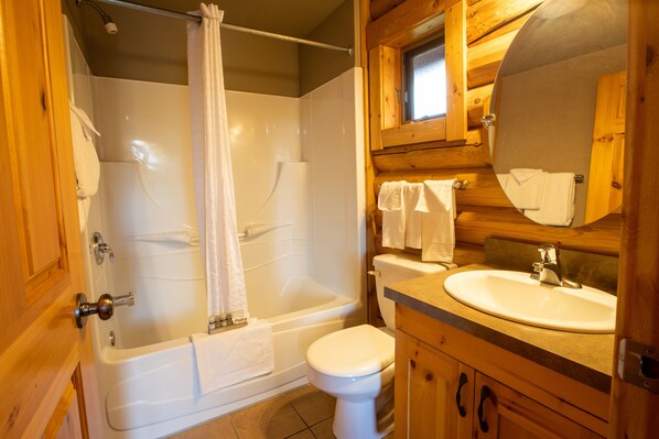 A bathroom with a bathtub, toilet, and sink.