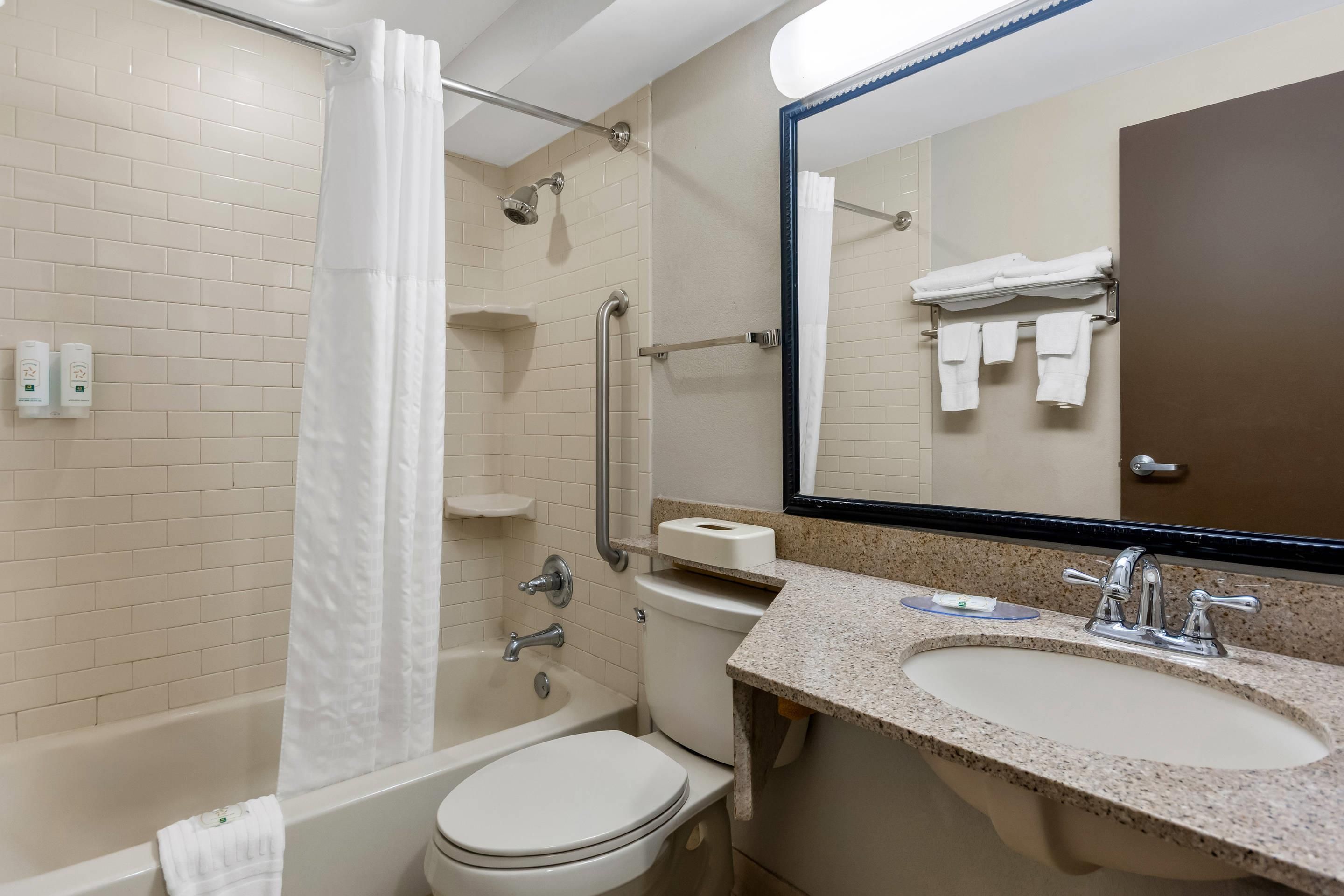 A bathroom with a bathtub, toilet, sink, and a shower with a curtain.