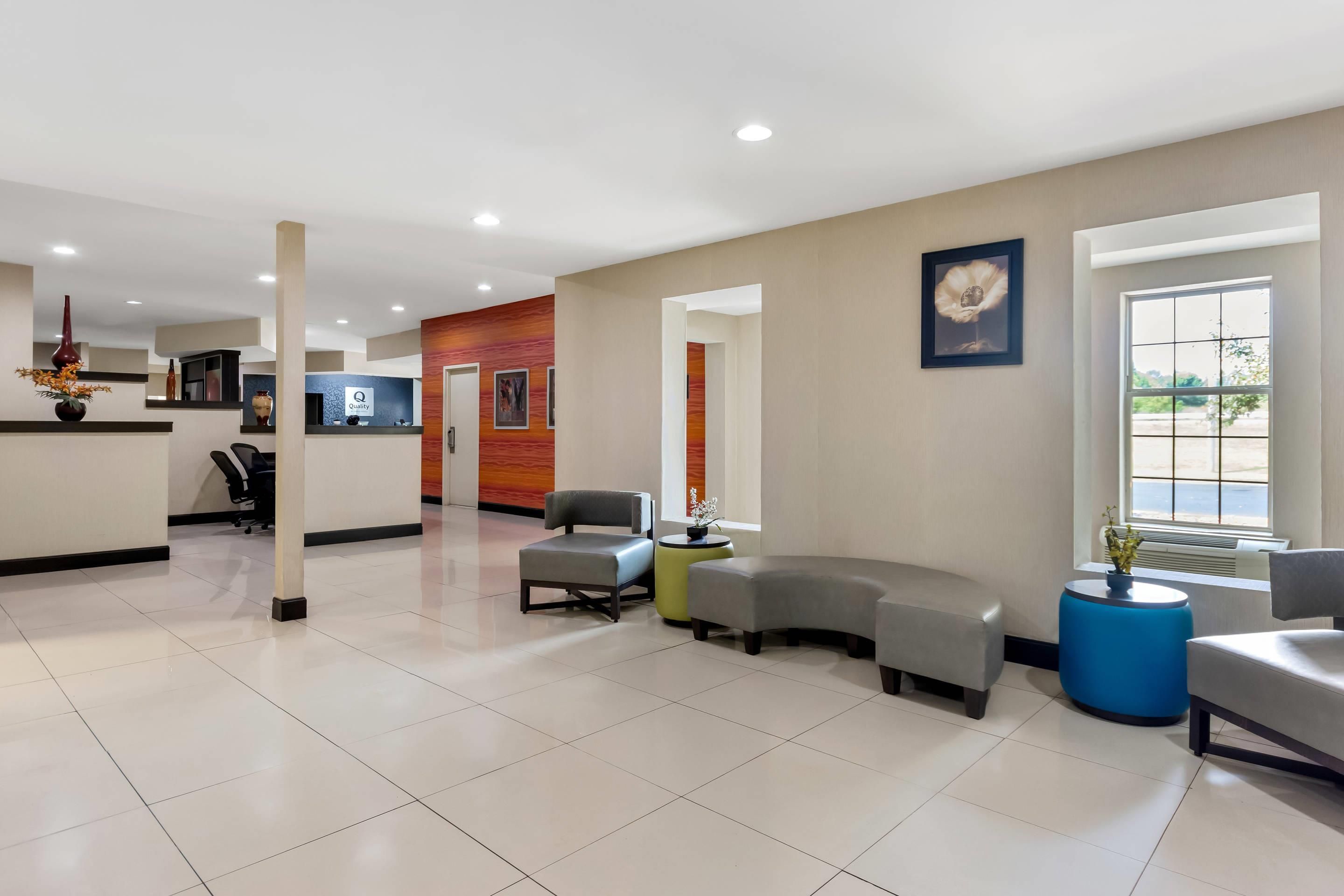 A spacious lobby with a reception desk, seating area, and a large window providing natural light.