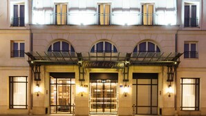 A hotel facade with a central entrance, multiple balconies, and a glass canopy over the entrance. - Hôtel l'Elysée Val d'Europe (Serris)