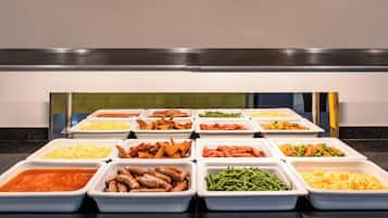 A buffet with various food options including meats, vegetables, and casseroles.