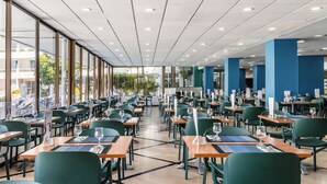 A spacious restaurant with high ceilings, large windows, and a modern interior. - Catalonia Oro Negro (Arona)