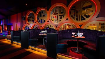 Uma área de estar moderna com assentos e um bar.