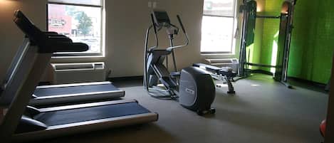 Un gimnasio con cintas de correr, elípticas y máquinas de pesas.
