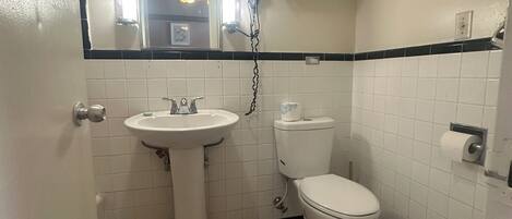 Een kleine badkamer met een wastafel, toilet en spiegel.