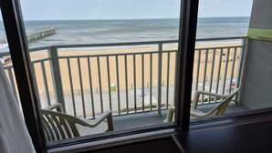 A balcony with a view of a beach and pier. - Sandcastle Resort On The Beach (Virginia Beach)