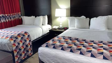 Een hotelkamer met twee bedden, een nachtkastje met een lamp en een telefoon.