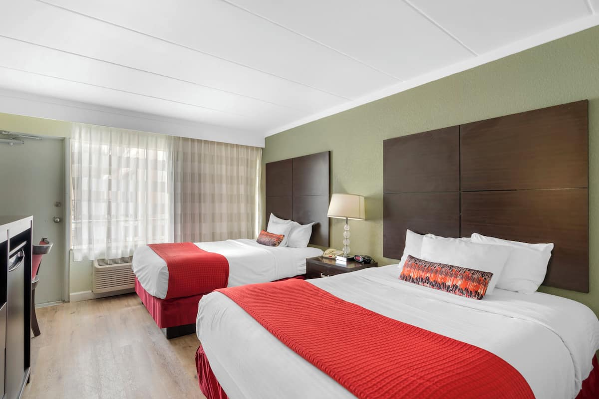 Una habitación de hotel con dos camas, un escritorio y una silla.