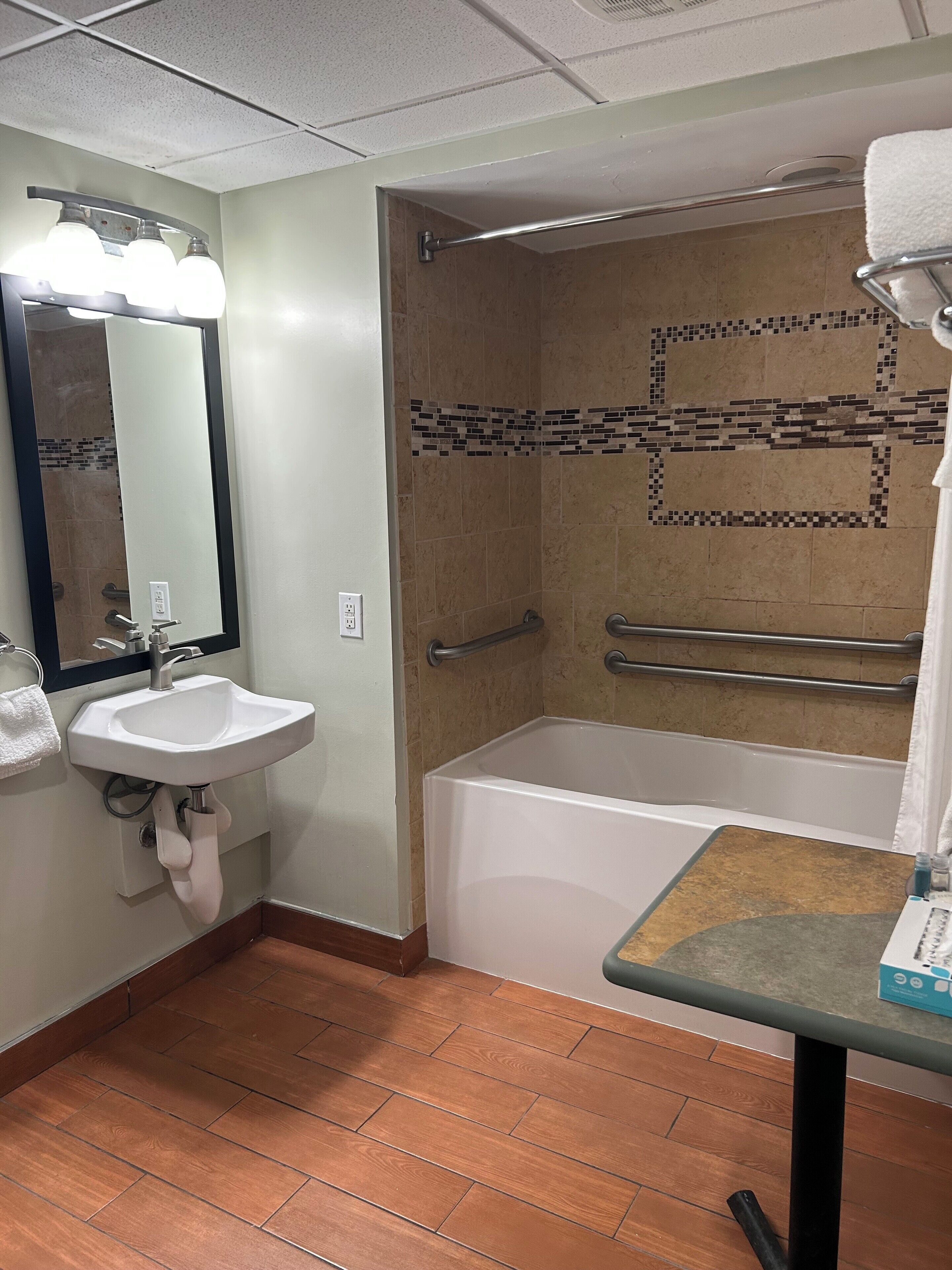 Un baño con lavamanos, espejo y zona de ducha.