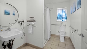 Bagno con lavandino, portasciuga, WC e zona doccia.