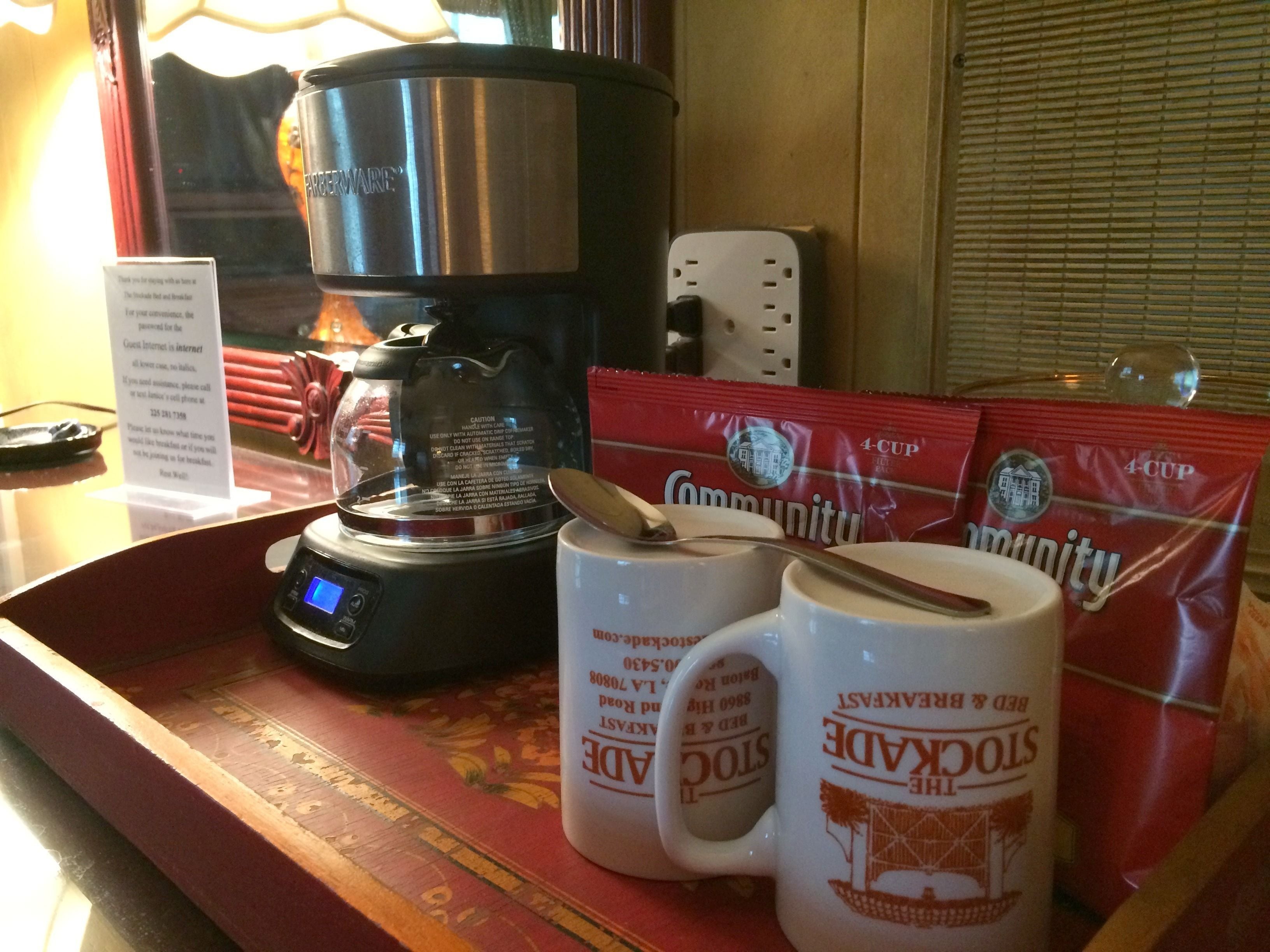 Una moka, due tazze e quattro capsule di caffè su un vassoio.