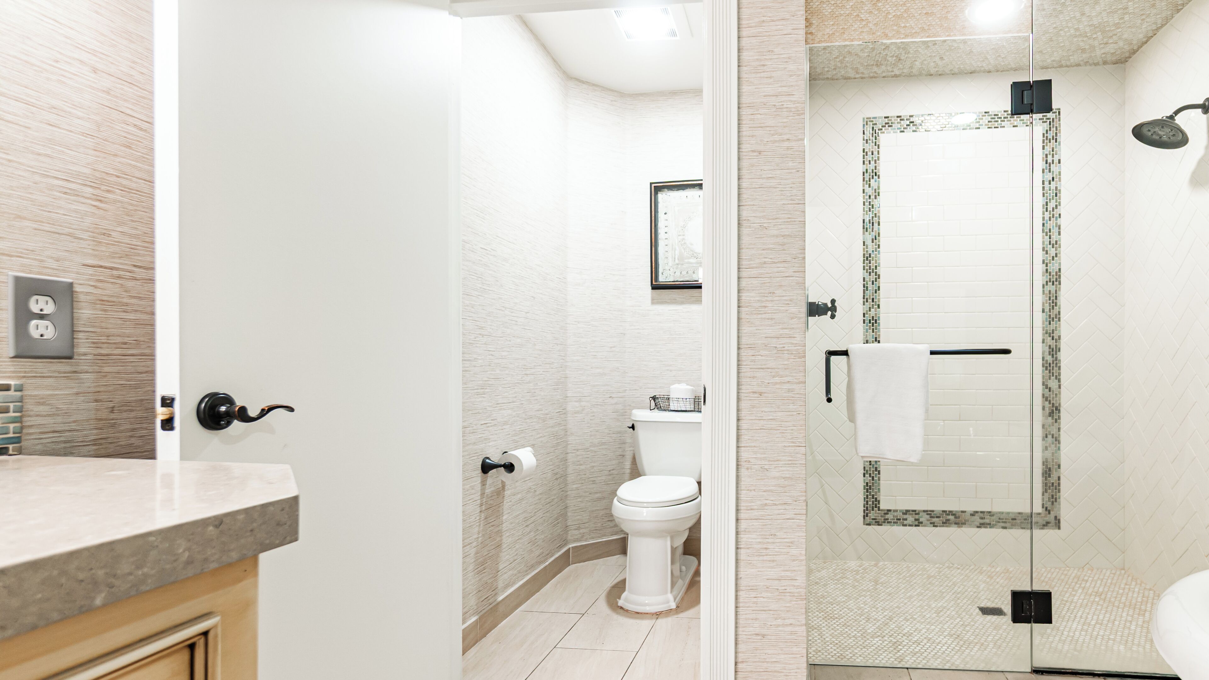 Un baño moderno con inodoro, zona de ducha e lavabo.