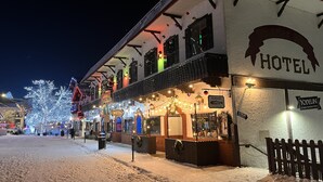 A hotel with a snow-covered ground, illuminated by string lights, and a sign reading "YODELIN". - Hotel Leavenworth (Leavenworth)