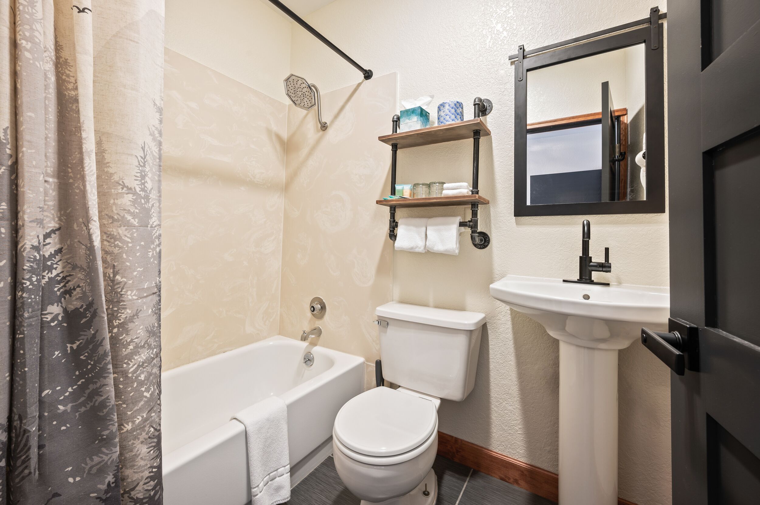 A bathroom with a bathtub, toilet, and sink.