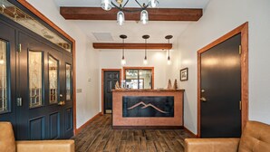 A reception area with a wooden reception desk, leather sofas, and a wooden floor. - Hotel Leavenworth (Leavenworth)