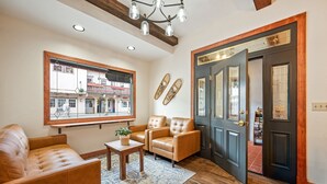 A living room with leather sofas, a coffee table, and a large window. - Hotel Leavenworth (Leavenworth)